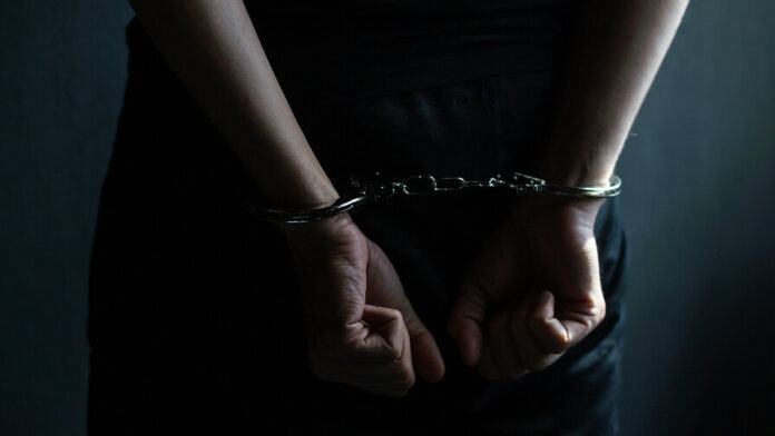 Male,Hands,In,Handcuffs,Black,Background